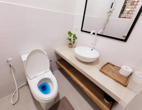 a bathroom with a white toilet and a sink at CAP Apartments in Talibon