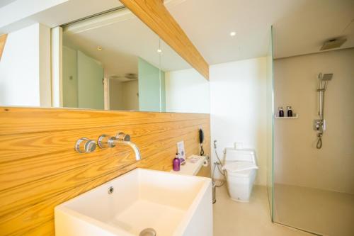 y baño con lavabo, aseo y espejo. en Centara Q Resort Rayong en Mae Pim