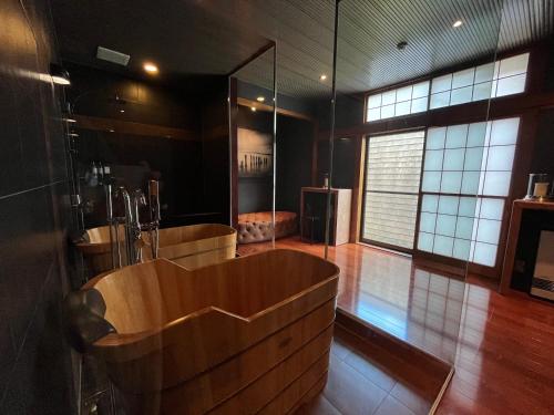 La salle de bains est pourvue d'une baignoire en bois. dans l'établissement Hakuba Mountain Lodge, à Hakuba