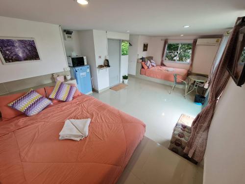 um quarto com uma cama laranja e uma sala de estar em เขาค้อออฟเลิฟ em Khao Kho