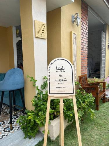 a sign in the grass in front of a house at Laman Zavilla Dhoma 1 in Sungai Pelik