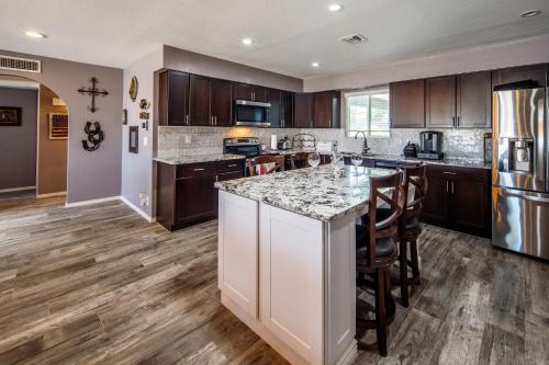 an open kitchen with a large island with bar stools at Coral Beauty! Heated Pool & Spa! in Lake Havasu City