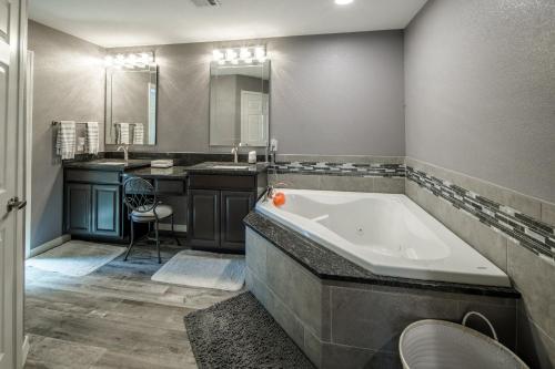 a large bathroom with a tub and a sink at Coral Beauty! Heated Pool & Spa! in Lake Havasu City