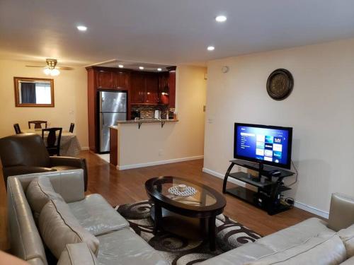 a living room with a couch and a flat screen tv at Beautiful Spacious 2 Bedroom, 2 Bathroom Condo in Long Beach