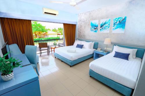 a bedroom with two beds and a couch and a chair at Villea Morib in Morib