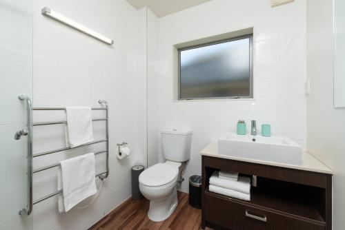 un bagno bianco con un water e un lavandino di Paihia Beach 1 Bedroom Apartment a Paihia