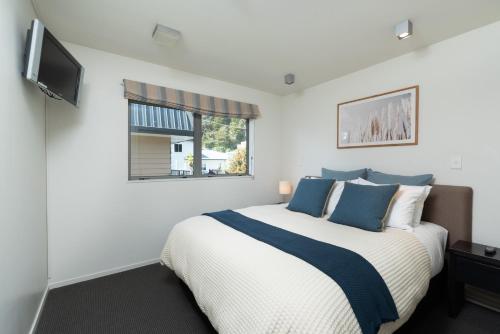 una camera da letto con un letto grande e una televisione di Paihia Beach 1 Bedroom Apartment a Paihia