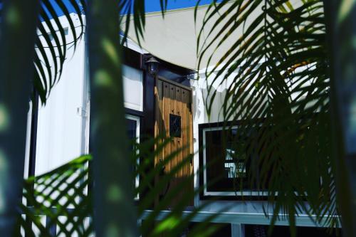 an open door of a house with a palm tree at Vacation Village Okinawa - Nakijin in Nakijin