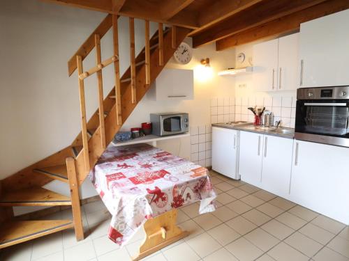 une cuisine avec une table et un escalier en colimaçon dans l'établissement Appartement cosy, proche centre, 6 pers, terrasse, parking, WiFi, équipements complets - FR-1-623-290, aux Gets