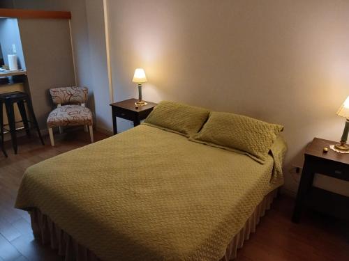 um quarto com uma cama, uma cadeira e candeeiros em Terra1 em San Carlos de Bariloche