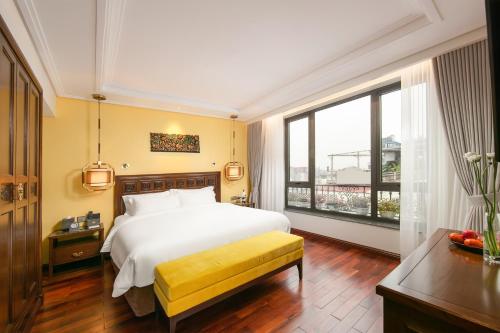 a bedroom with a bed and a large window at Lucien Hanoi Lakeside Hotel & Rooftop in Hanoi