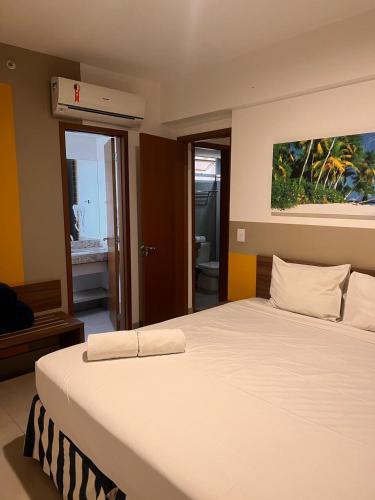 a large white bed in a room with a bathroom at Olímpia Park Resort - Apto 2 Quartos 8 Pessoas in Olímpia