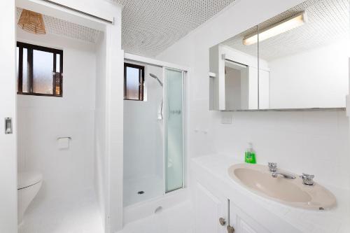 a white bathroom with a sink and a shower at Sunlake 7 in Forster