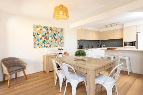 a kitchen and dining room with a wooden table and chairs at Sunlake 7 in Forster