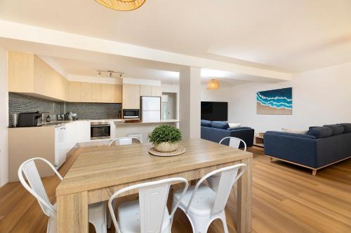 a kitchen and living room with a wooden table and chairs at Sunlake 7 in Forster