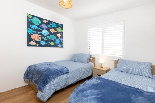 a bedroom with two beds and a painting on the wall at Sunlake 7 in Forster