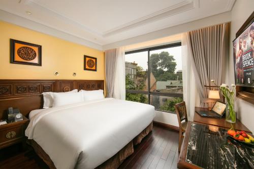 a hotel room with a large bed and a window at Lucien Hanoi Lakeside Hotel & Rooftop in Hanoi