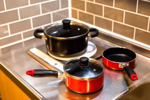 two pots and pans sitting on a stove top at THE BONDS HOTEL TOKYO in Tokyo