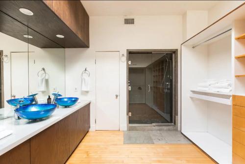 a bathroom with two blue sinks and a shower at TuCasa Luxury 4 Story Villa in Downtown San Diego Little Italy in San Diego