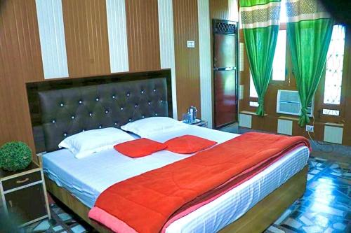 a bedroom with a large bed with red pillows at Flagship Corbett Farm Homestay in Rāmnagar