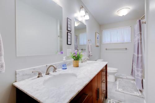 a white bathroom with a sink and a toilet at The Greenwood in Manhattan