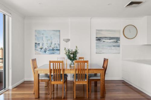 a dining room with a wooden table and chairs at The Coogee View Beachfront Serviced Apartments in Sydney