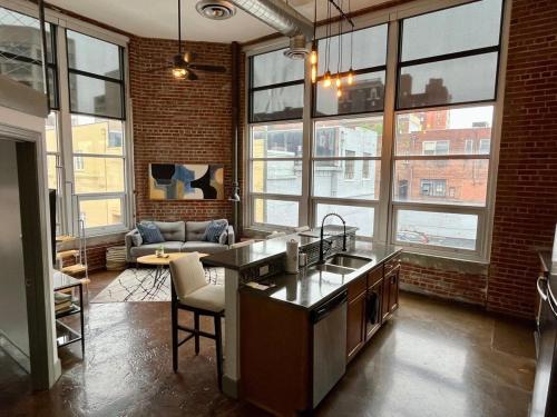a kitchen with a sink and a couch in a room at Exceptional 1 Br Apartment Downtown W Study Loft in Roanoke