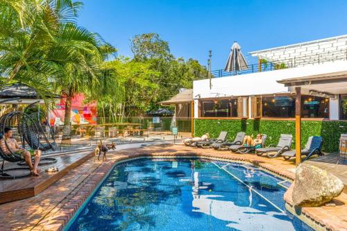 a swimming pool with chaise lounge chairs and a resort at Aquarius Backpackers Resort in Byron Bay