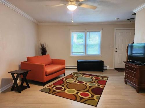 sala de estar con sofá naranja y alfombra en Cozy cute Relaxing home, en Southbury
