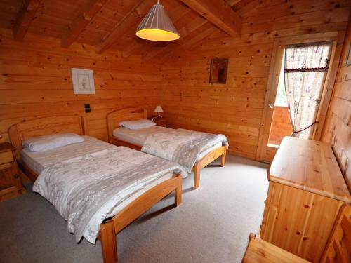 - une chambre avec 2 lits dans une cabane en bois dans l'établissement Chalet familial au pied des pistes avec terrasse et balcon - FR-1-623-51, aux Gets