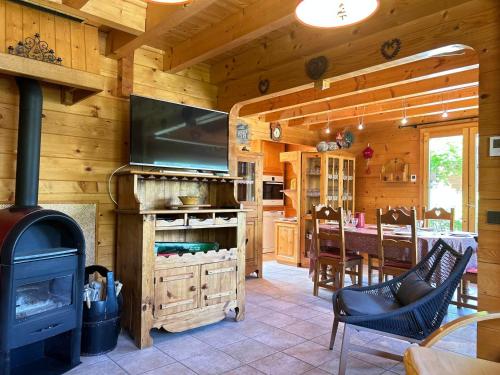 - une cuisine et une salle à manger avec une cheminée dans une cabane en rondins dans l'établissement Chalet familial au pied des pistes avec terrasse et balcon - FR-1-623-51, aux Gets