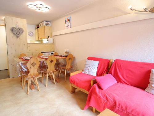 un salon avec un canapé rouge et une table dans l'établissement Les Gets - Appart cosy avec mezzanine et parking, proche pistes - FR-1-623-145, aux Gets