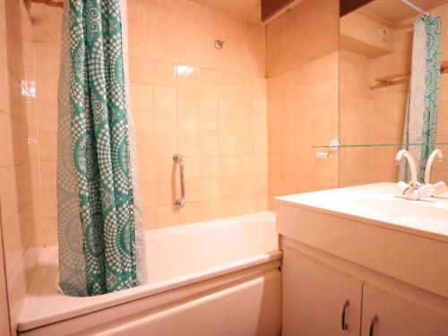 a bathroom with a tub and a sink and a shower curtain at Les Gets - Appart cosy avec mezzanine et parking, proche pistes - FR-1-623-145 in Les Gets