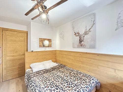 - une chambre avec un lit et une photo de cerf sur le mur dans l'établissement Appartement neuf aux Gets, à 50m des pistes, avec balcon et parking - FR-1-623-242, aux Gets