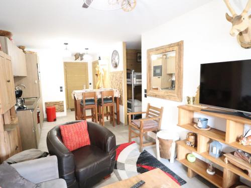 un salon avec un fauteuil en cuir et une télévision dans l'établissement Appartement neuf aux Gets, à 50m des pistes, avec balcon et parking - FR-1-623-242, aux Gets