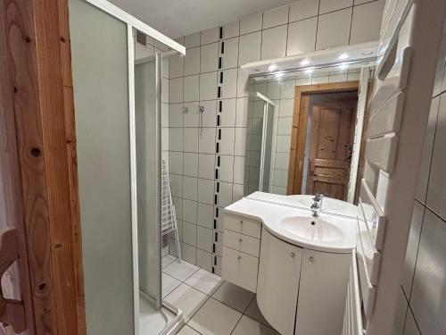 La salle de bains blanche est pourvue d'un lavabo et d'un miroir. dans l'établissement Appartement Les Gets, 2 pièces, 4 personnes - FR-1-623-185, aux Gets