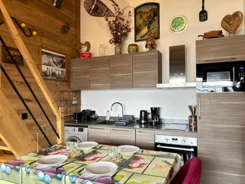 une cuisine avec une table avec des assiettes dessus dans l'établissement Appartement Haut Standing au Cœur des Gets - Proche Commerces, Garage et Spa - FR-1-623-270, aux Gets