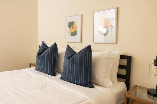 Schlafzimmer mit einem Bett mit blauen und weißen Kissen in der Unterkunft Luxury 2 Bedroom Apt With Exposed Brick Downtown in Roanoke