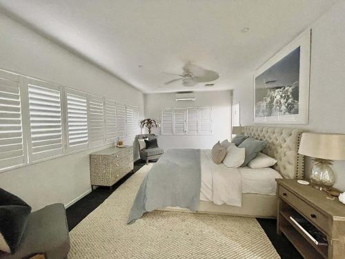 a bedroom with a bed and a desk and a chair at Luxe coastal village home, Peregian Beach in Peregian Beach