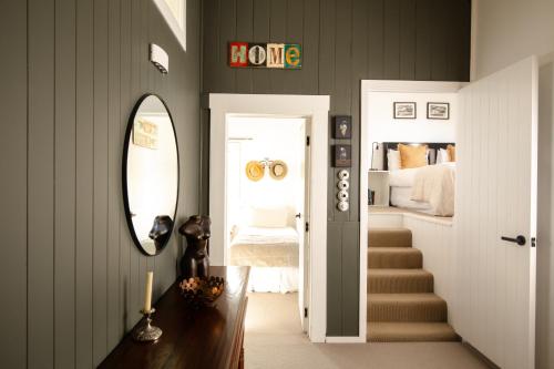 a hallway with a bedroom with a bed and a mirror at The Loft House in Kaikoura