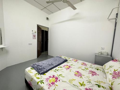 um quarto com uma cama com flores em Jiaxin Dormitory-Setia Indah 家馨青年旅宿 em Johor Bahru