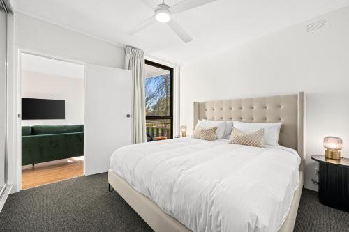 a white bedroom with a large bed and a window at Peppertree Apartments in Sale