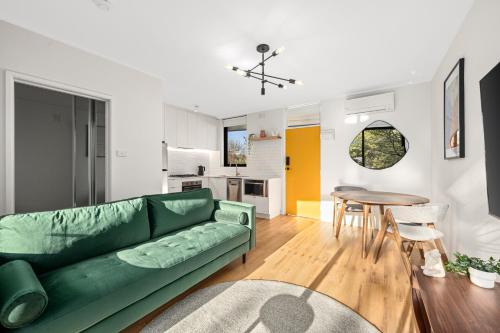 a living room with a green couch and a table at Peppertree Apartments in Sale
