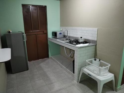 a small kitchen with a stove and a microwave at La Casa Buena Esperanza in Penonomé