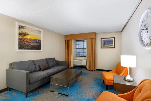 a living room with a couch and chairs and a clock at Days Inn by Wyndham Casper in Casper