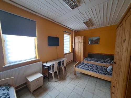 Habitación con 2 camas y escritorio. en COLLINGO Belvárosi Szállás, en Kazincbarcika