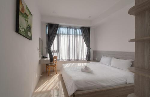 um quarto com uma cama branca e uma janela em Căn hộ Mường Thanh Viễn Triều - Review Nha Trang em Nha Trang