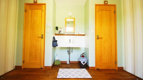 La salle de bains est pourvue de deux portes et d'un lavabo. dans l'établissement Panari-パナリ, à Ube