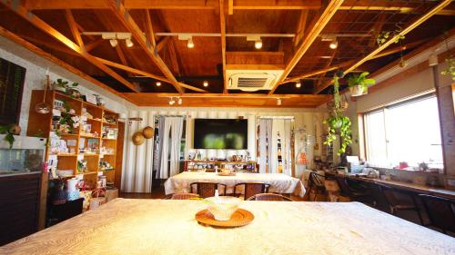 a living room with a table and a tv on the ceiling at Panari-パナリ in Ube