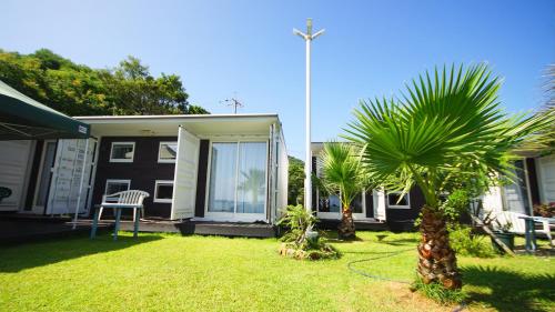 a yard with two palm trees and a house at Panari-パナリ in Ube